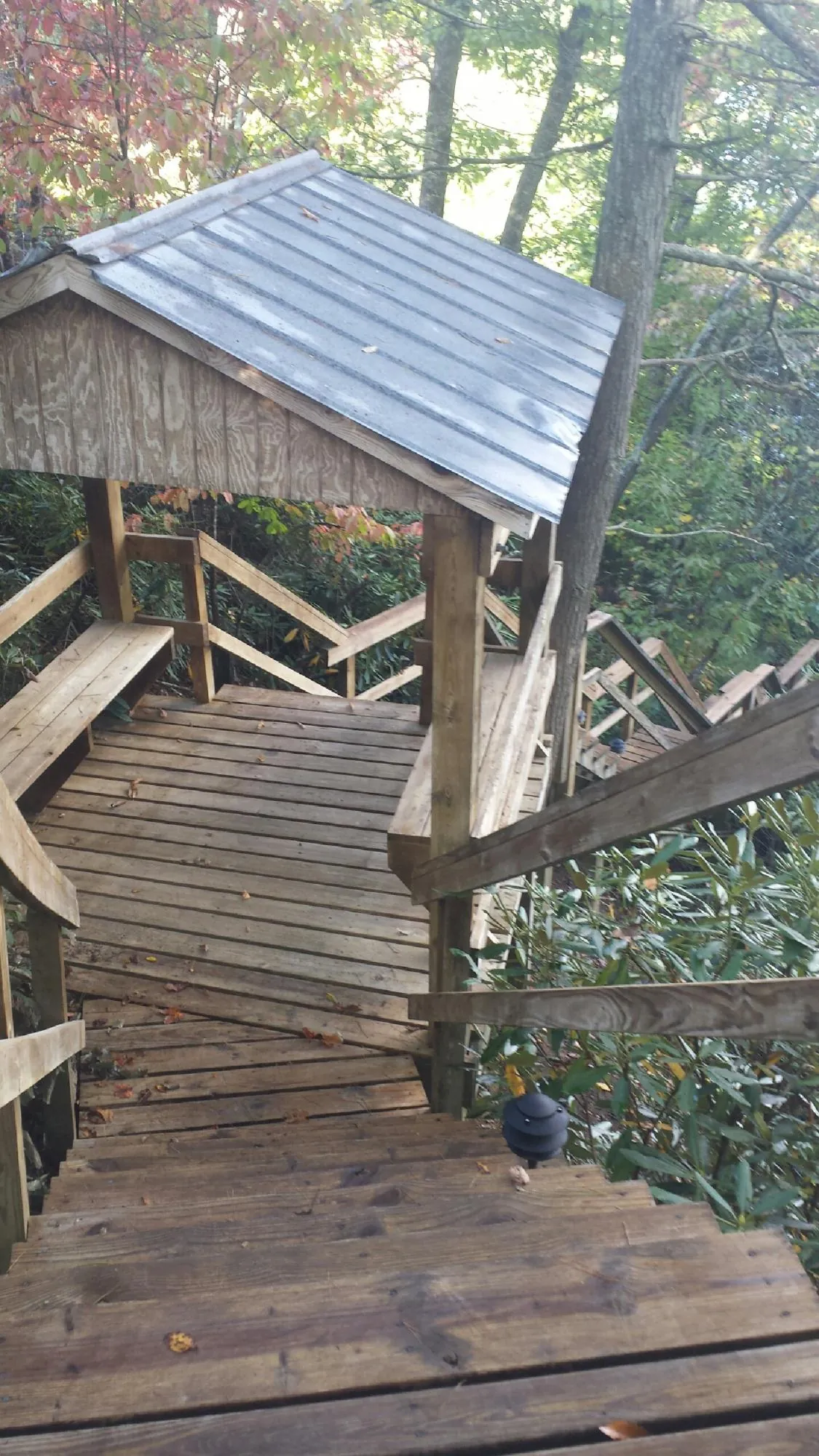 Metal roofed shelter over wooden steps on a wooded walkway — Skylight Repair & Installation work by our crew in Appomattox