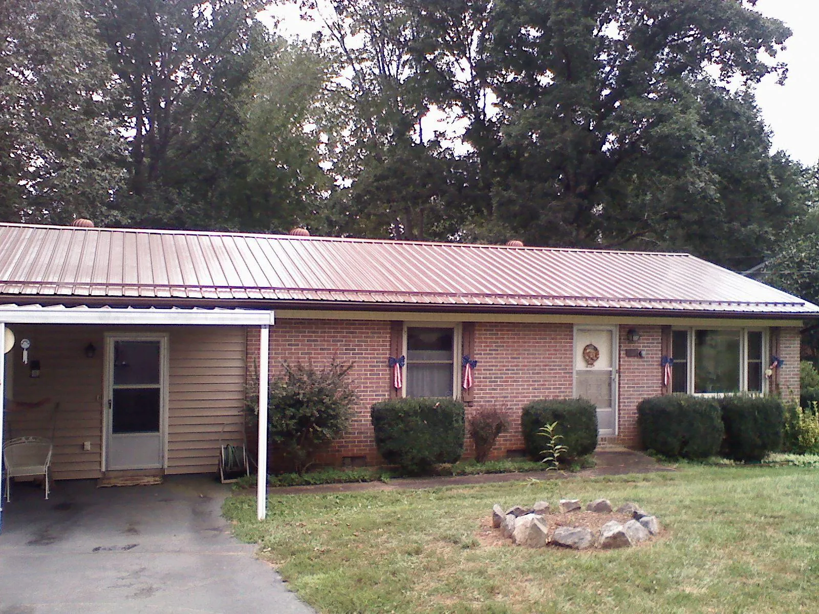 Bronze metal roof and carport on a brick ranch home — Roof Repair work by our crew in Appomattox