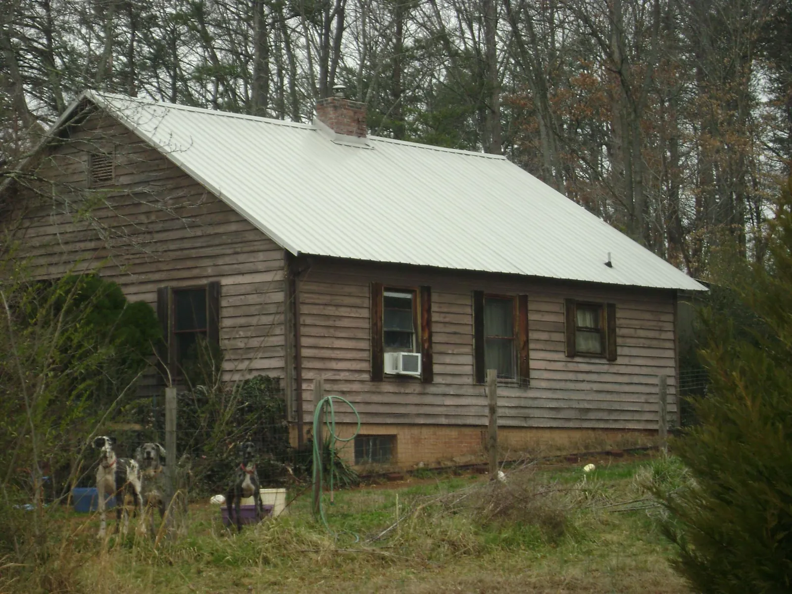 White metal roof on an old wood sided farmhouse, from a Metal Roof Installation job in Appomattox
